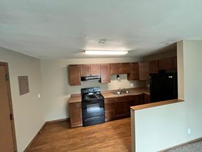 Grand Forks apartment for rent - an empty kitchen with wooden cabinets and black appliances