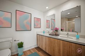 Los Angeles apartment for rent - A bathroom with a white toilet, a wooden vanity, and a potted plant.