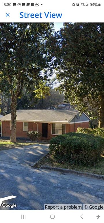 Atlanta house for rent - A street view of a residential area with houses and trees.