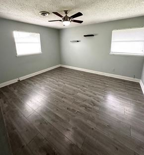 Lafayette house for rent - an empty living room with wood floors and a ceiling fan
