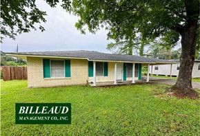 Lafayette house for rent - a small brick house with green shutters and a tree