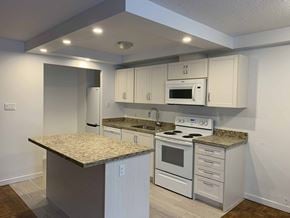 Toronto apartment for rent - A kitchen with white cabinets and a granite countertop. at 177 Saint George in Toronto, CA