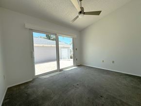 Bradenton house for rent - a living room with a ceiling fan and a sliding glass door