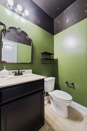 Maple Hill house for rent - A bathroom with a green wall and a white toilet.