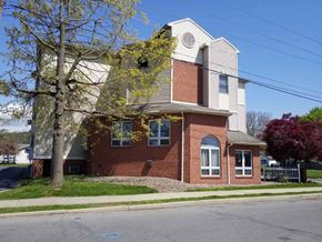 Williamsport apartment for rent - a brick house with a white roof and a tree in front of it