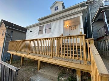 Morgantown apartment for rent - a backyard deck with a white house with a wooden railing