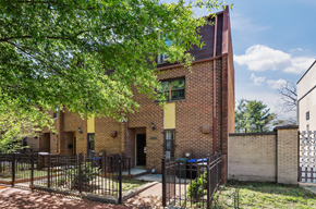 Washington apartment for rent - the front of a brick house with a gate and a tree
