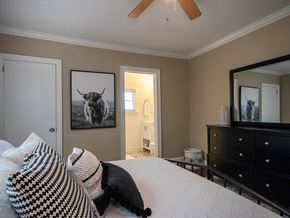 Greenville house for rent - a bedroom with a bed and a dresser and a picture of a bull