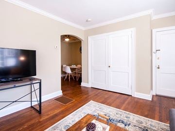 Greenville house for rent - a living room with a tv and a door to a dining room