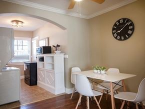 Greenville house for rent - a dining room with a table and chairs and a clock on the wall
