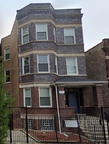 Chicago apartment for rent - A brick building with a black fence in front.
