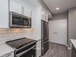Waukee apartment for rent - A modern kitchen with a stainless steel refrigerator, microwave, and oven.