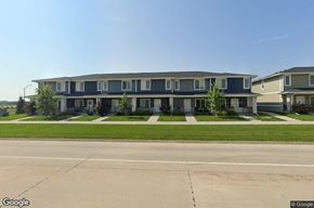 Waukee apartment for rent - A street view of a row of houses with a clear blue sky above.