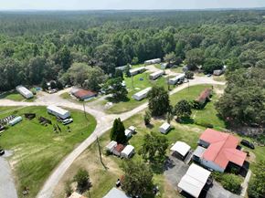 Milledgeville apartment for rent - A bird's eye view of a rural area with buildings, trees, and a road.