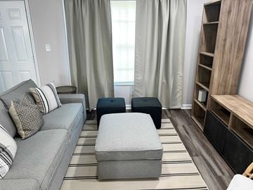 Atlanta apartment for rent - A living room with a grey couch and ottomans.