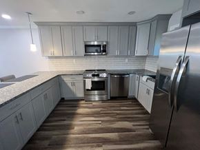 Atlanta apartment for rent - A modern kitchen with a stainless steel refrigerator and wooden flooring.