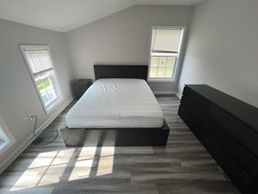 Atlanta apartment for rent - A bedroom with a large bed and a window letting in sunlight.