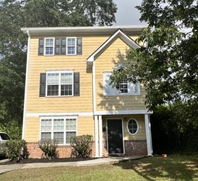 Atlanta apartment for rent - A yellow house with black shutters and a black door.
