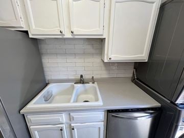 Atlanta house for rent - A kitchen with white cabinets and a white sink.