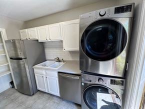 Atlanta house for rent - A washing machine is on top of a dryer in a laundry room.