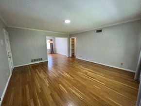 Atlanta house for rent - A room with wooden flooring and a doorway leading to another room.