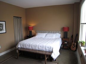 Louisville apartment for rent - a bedroom with a large bed and a guitar on the wall