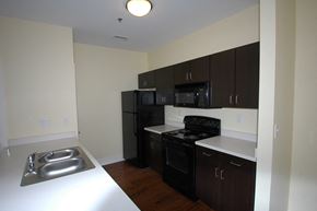 Louisville apartment for rent - a kitchen with black appliances and white countertops in an empty apartment