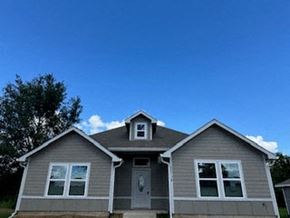 Prairie View apartment for rent - A grey house with a brown roof and a white door.