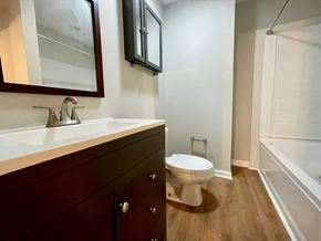 Pewee Valley house for rent - A white toilet sits in a bathroom with a wooden vanity and a glass shower door.