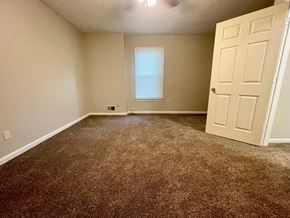 Pewee Valley house for rent - A room with a brown carpet and a white door.