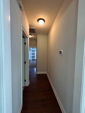 Baker house for rent - a hallway with a wood floor and white walls and a ceiling light