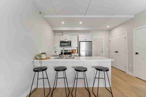 Winnipeg apartment for rent - A kitchen with a bar stool in front of it.