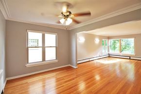 Oak Park apartment for rent - an empty living room with a ceiling fan and wood floors