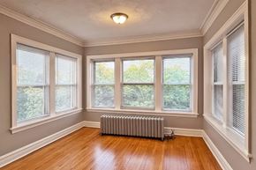 Chicago apartment for rent - A room with wooden floors and a radiator.