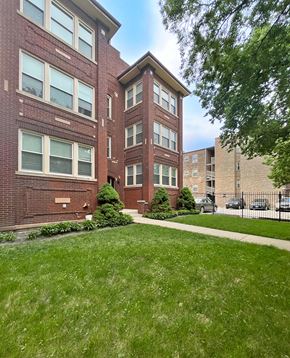 Chicago apartment for rent - A red brick building with a green lawn in front.