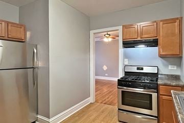 Chicago apartment for rent - A kitchen with a stainless steel refrigerator and a stove top oven.