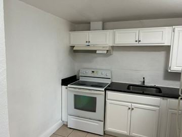 Fort Myers apartment for rent - A white kitchen with a stove and sink.