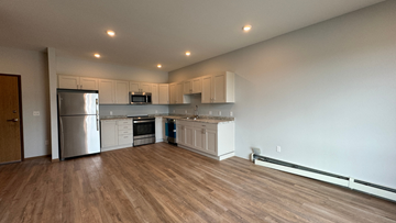 Fargo apartment for rent - a kitchen with white cabinets and a stainless steel refrigerator