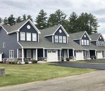 Pembroke apartment for rent - a large house with white garage doors and a lawn