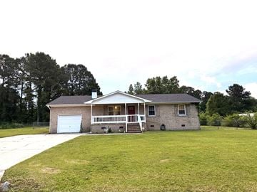 Jacksonville house for rent - a small brick house with a yard and a white garage door