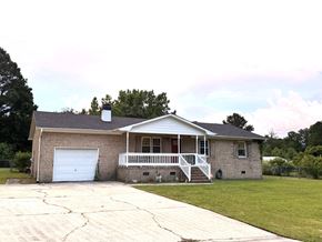 Jacksonville house for rent - a brick house with a white porch and a white garage door