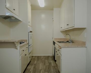 Sherman Oaks apartment for rent - A kitchen with white cabinets and a wooden floor.