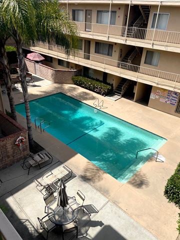 Sherman Oaks apartment for rent - A pool surrounded by a patio and a building.