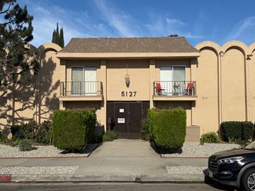Sherman Oaks apartment for rent - A black car is parked in front of a beige house with the number 5127 on it.