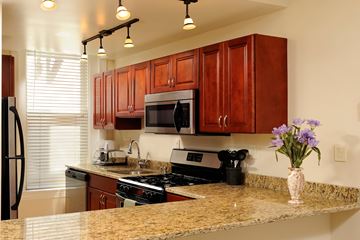 Washington apartment for rent - A kitchen with brown cabinets and granite countertops.