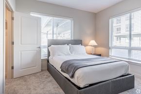 Troutdale apartment for rent - A bedroom with a large bed and a window with blinds.