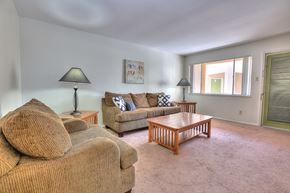 Albuquerque apartment for rent - A living room with a brown couch, a wooden coffee table, and two lamps.
