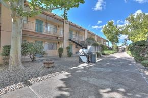 Albuquerque apartment for rent - A sunny day at a residential area with apartment buildings and a gravel driveway.