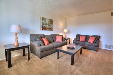 Albuquerque apartment for rent - A living room with a grey couch and a small table.