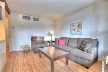 Albuquerque apartment for rent - A living room with a grey couch and a wooden coffee table.